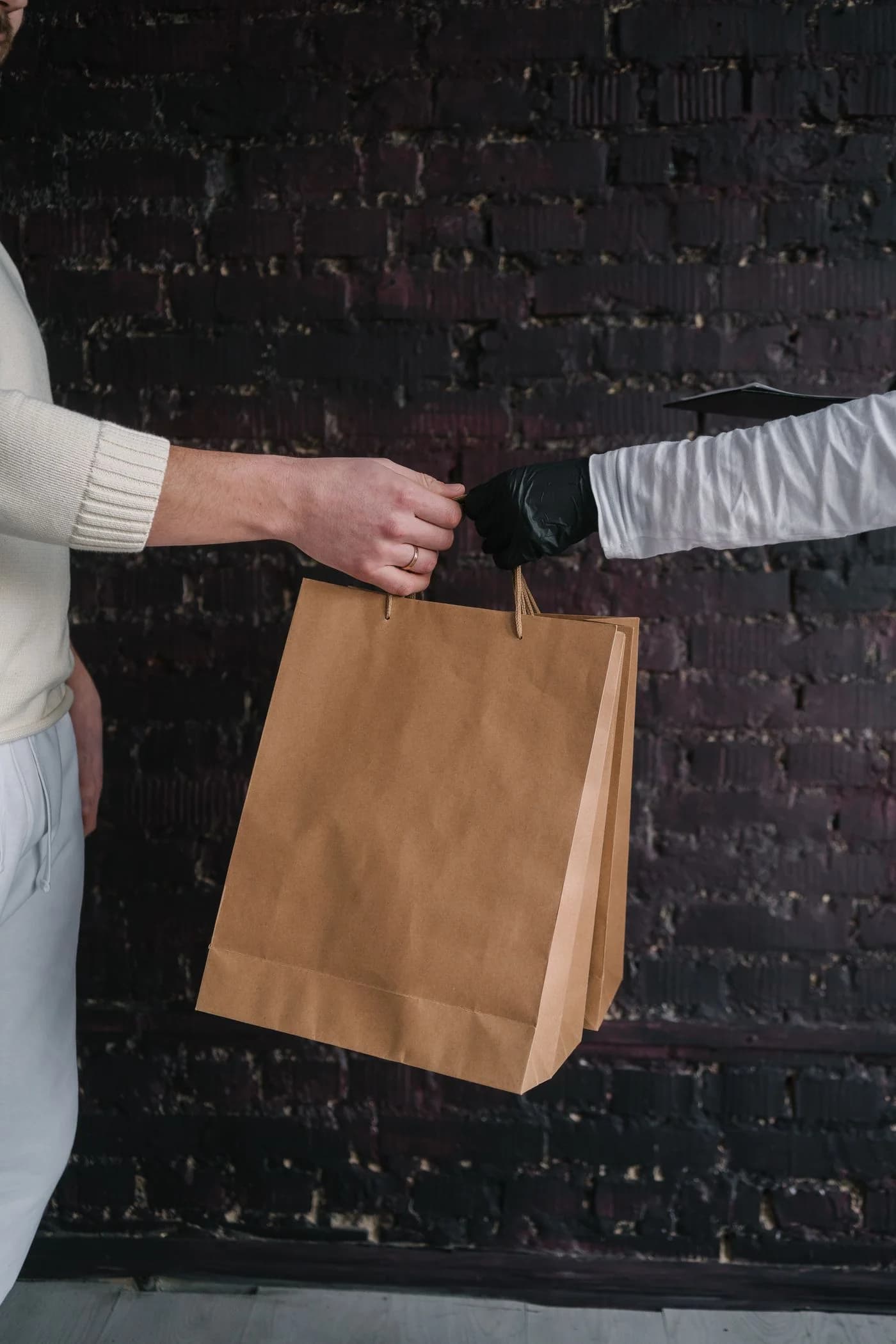 A shopping bag changing hands, connecting a store and its customer