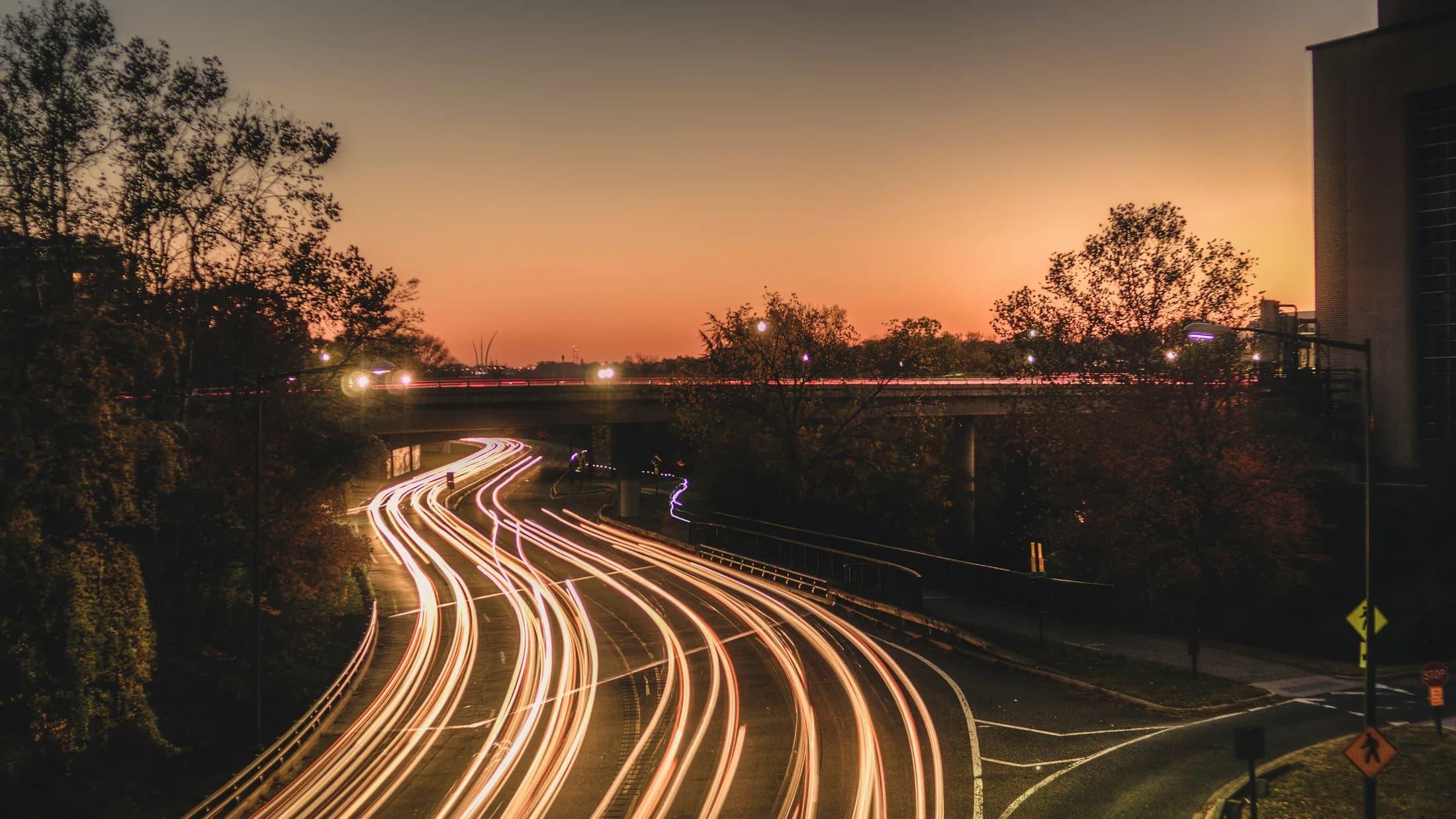 Traffic moving along a road at sunset