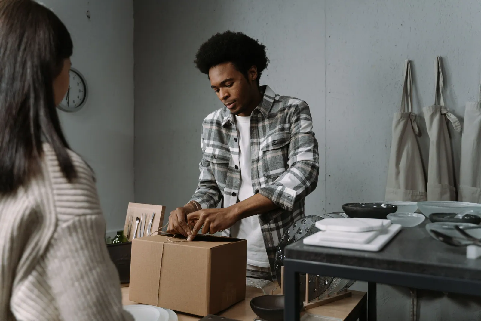 A shopkeeper packing a customer order at a counter.