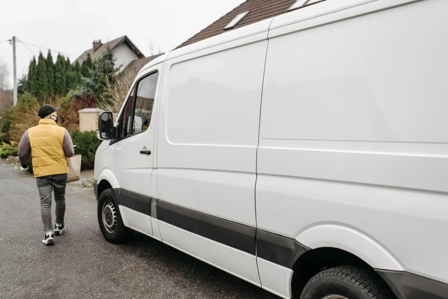Courier carrying parcel to residential entrance