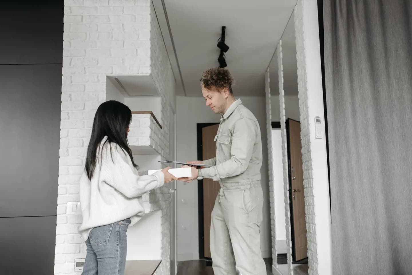 Close up physical parcel exchange between courier and customer